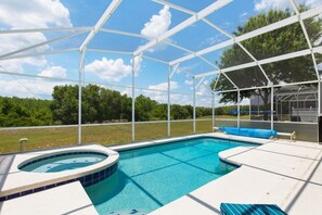 A covered outdoor swimming pool with a hot tub, surrounded by a white canopy structure. - Stunning Golf Community Villa with Pool, Spa, and Near Attractions (Davenport)