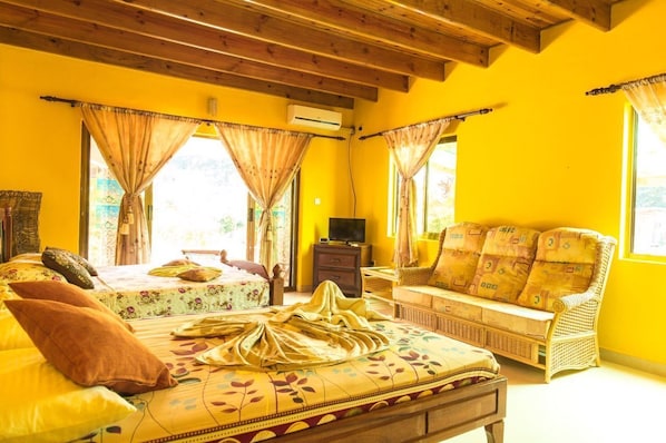 A room with a bed, a sofa, and a TV.