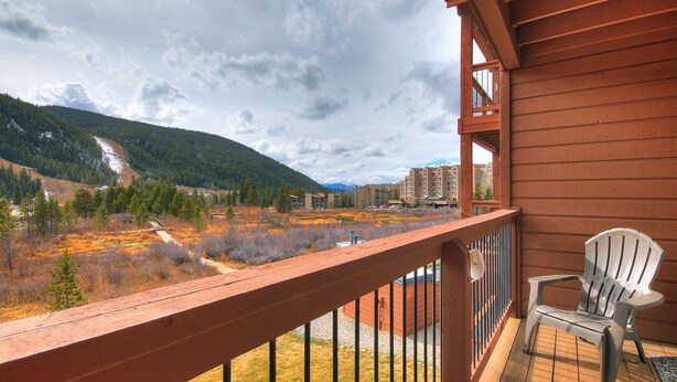 A balcony with a view of a mountainous landscape, a chair, and a building in the background. - Spacious Centrally Located/Short Walk to the Lifts/Hot Tub Access (Keystone)