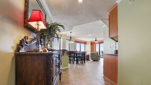 Una cocina amplia con comedor, que cuenta con un armario de madera, una lámpara roja y un ventilador de techo.