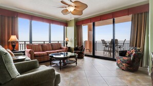 Un balcón amplio con vista al océano, amoblado con un sofá, sillones y un comedor.