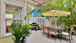 An outdoor patio with a dining table, chairs, and a grill. - **SEA CAPTAIN'S HAVEN** Luxury Villa & Pool + Last Key White Glove Service... (Key West)