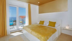 Un dormitorio con una cama grande, un balcón con vistas y una lámpara en el techo.