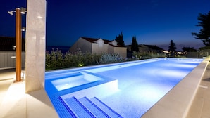 Una piscina con borde de baldosas y una fuente.