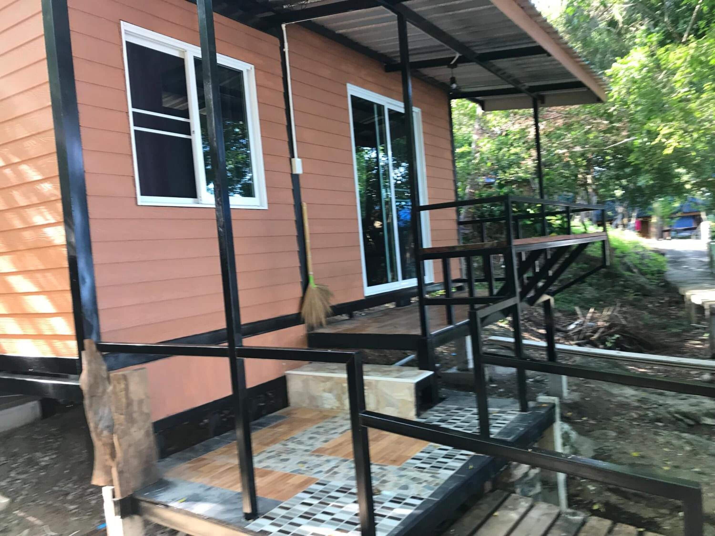 Una casa de dos pisos con un porche y una escalera.