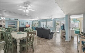 Relax in this spacious living area with a high ceiling, dining table, and comfortable sofa.