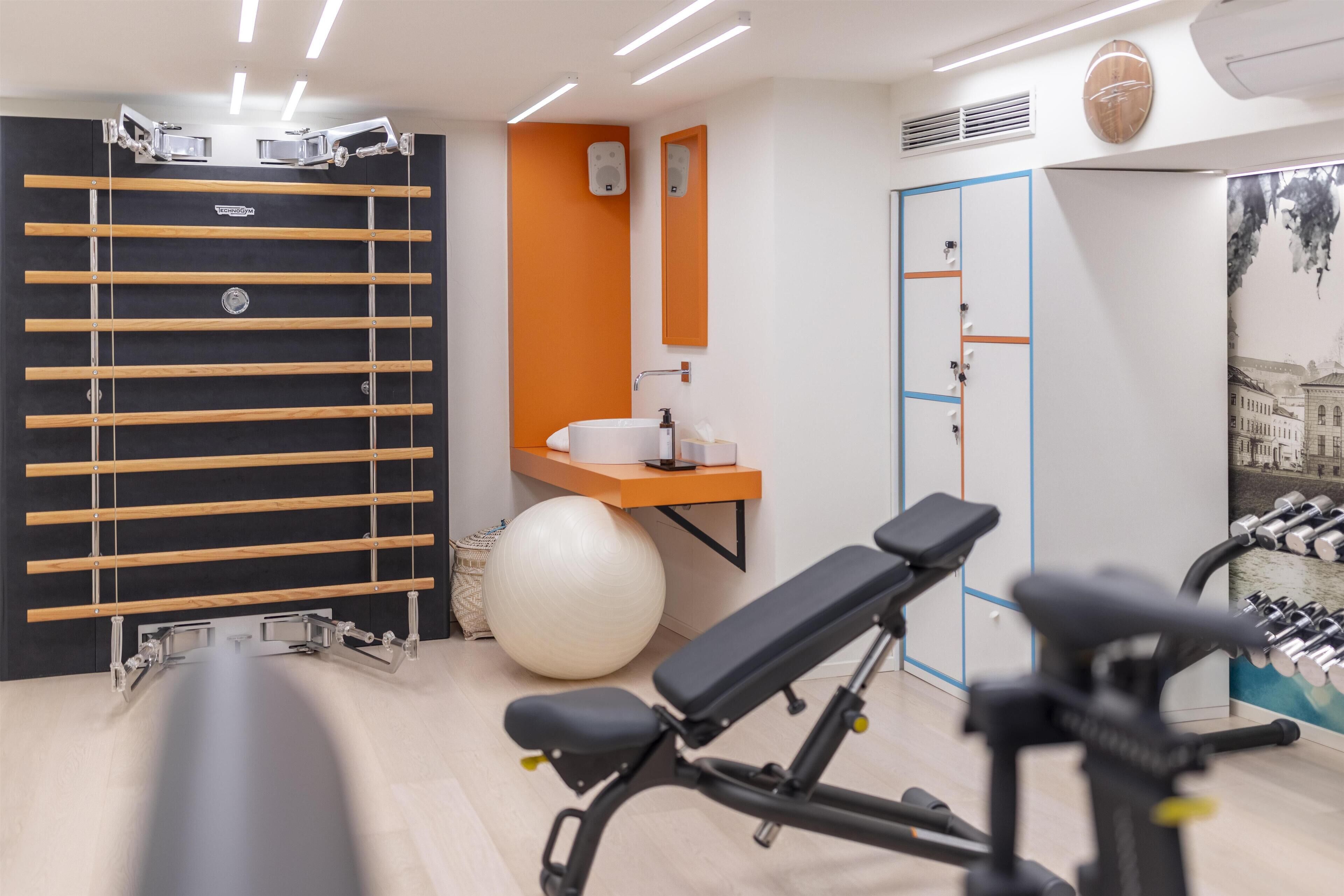 A gym with exercise equipment, a pull-up bar, a large exercise ball, and a mirror.
