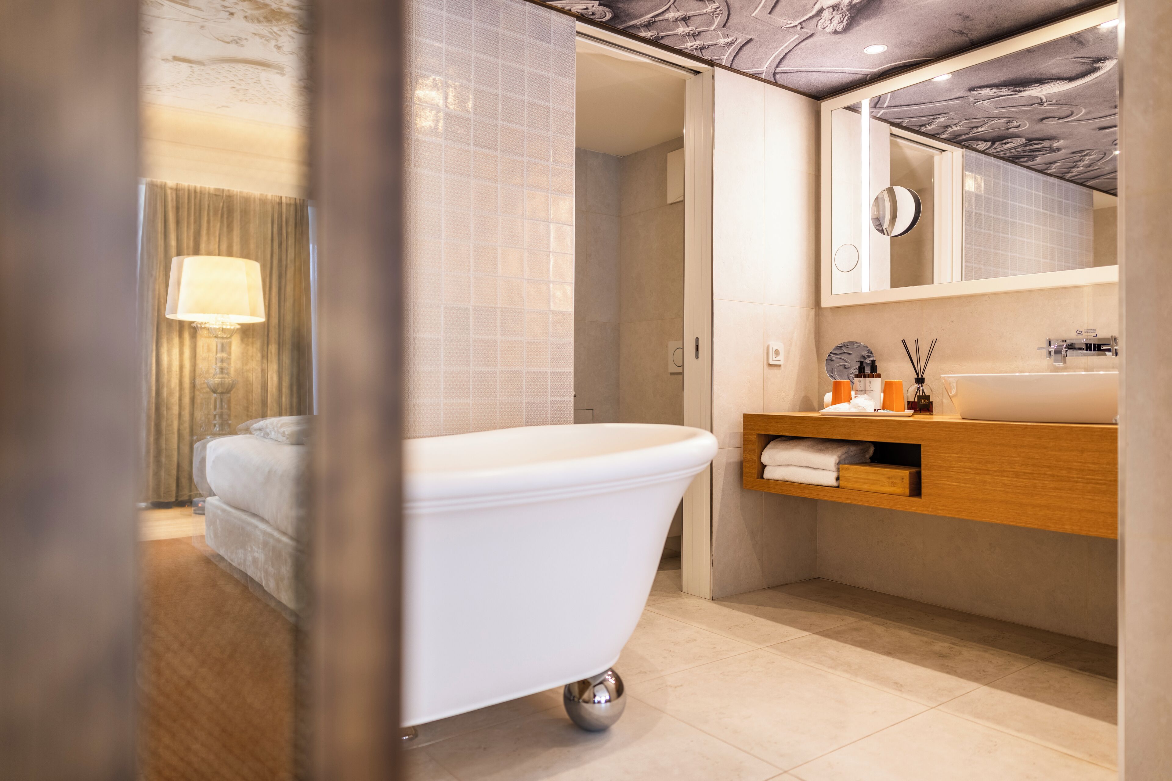 A modern bathroom with a freestanding bathtub, a wooden vanity, and a large mirror above the sink.