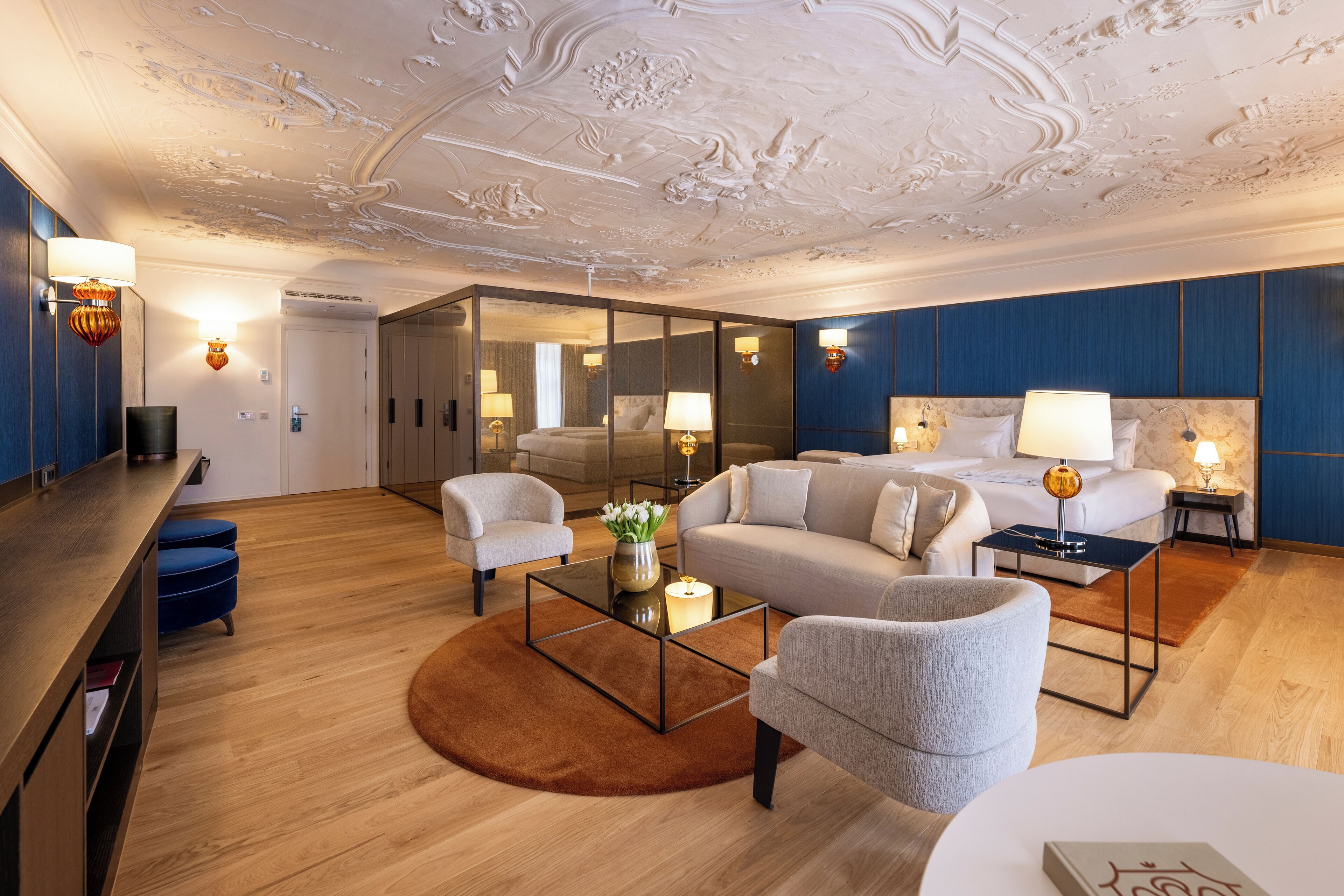 Ein modernes Hotelzimmer mit einem großen Bett, einer Couch, einem Couchtisch und einem Schreibtisch.