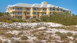 A multi-story hotel with balconies, located on a sandy beach with vegetation. - 202E - Newly Remodeled! (Gulf Shores)