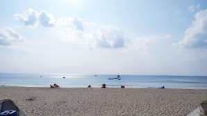 Une plage de sable avec des bateaux et un ciel dégagé.