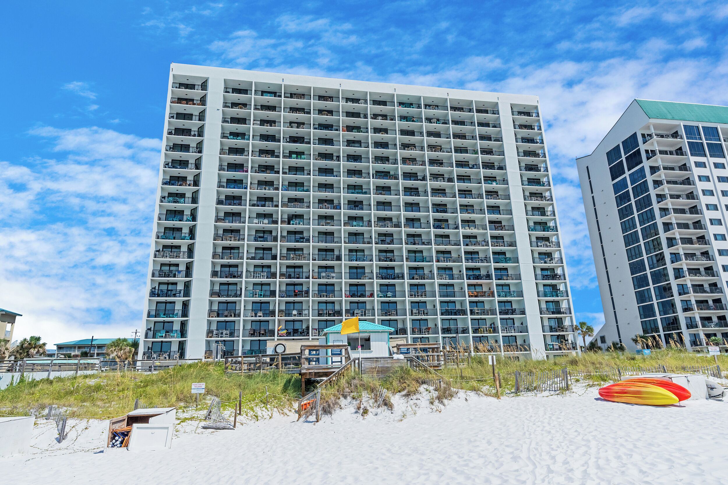 Un hôtel de grande hauteur doté de nombreux balcons et offrant une vue sur la plage.