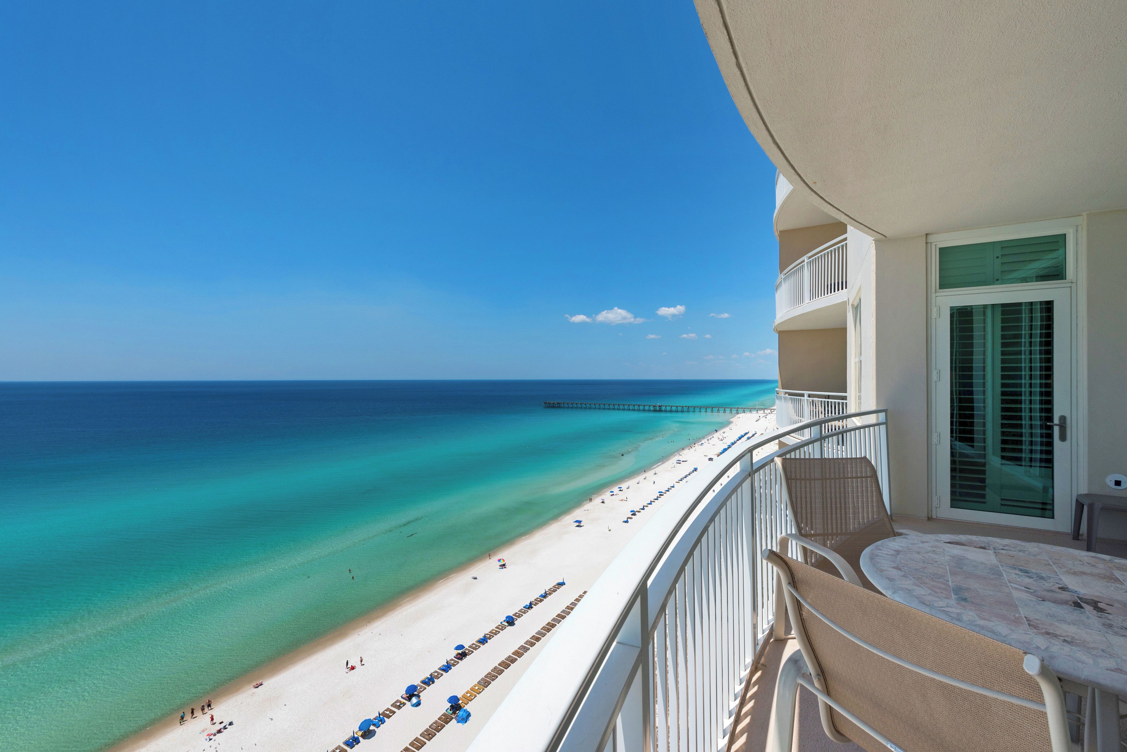 A balcony with a view of a beach and ocean.