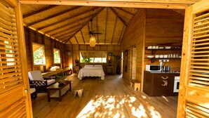 A wooden cabin interior with a bed, seating area, and kitchen. - BAYLEAF: The Perfect Hideaway near secluded beach (Hellene)