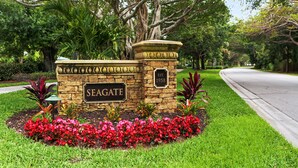 Een stenen bord met 'SEAGATE' en 'Opgericht 1958', dat het oprichtingsjaar aangeeft, omgeven door een verzorgde tuin met rode bloemen en groen gras.