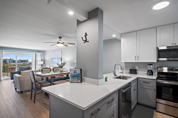 Una cocina moderna con una isla grande, electrodomésticos de acero inoxidable y vistas a la ciudad.
