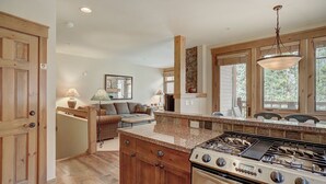 A kitchen with wooden cabinets, a granite countertop, and a gas stove. - Spacious Townhome/Pool and Hot Tub Access/Private Patio (Keystone)