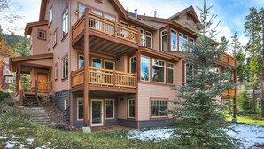 A multi-story log cabin with a balcony, large windows, and a snow-covered ground. - Spacious Townhome/Pool and Hot Tub Access/Private Patio (Keystone)
