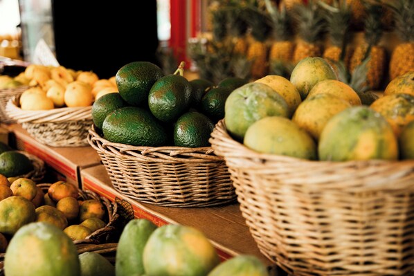 Una exhibición de frutas variadas, incluyendo aguacates, limones y piñas.