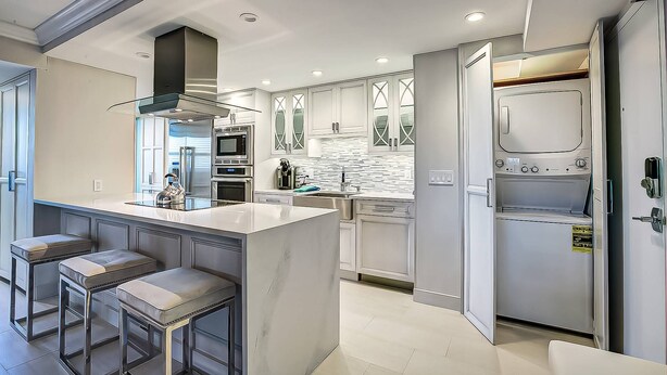 A modern kitchen with a central island, stainless steel appliances, and a large window. - Expansive Renovated Condo, Heated Pools, Tennis, Fishing on Intracoastal | Siesta Key Beach (Siesta Key)