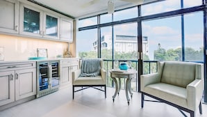 A modern kitchen with large windows, a ceiling fan, and a seating area with a view of the city. - Expansive Renovated Condo, Heated Pools, Tennis, Fishing on Intracoastal | Siesta Key Beach (Siesta Key)