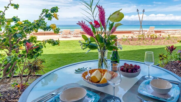 Ein Tisch ist für eine Mahlzeit mit Blick auf Strand und Meer gedeckt.