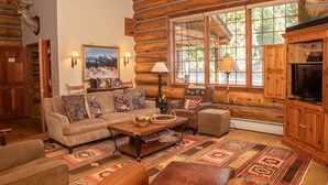 A log cabin interior with a sofa, armchairs, a coffee table, and a television. - Luxury Custom Log Cabin Retreat in Keystone/Large Private Patio (Keystone)