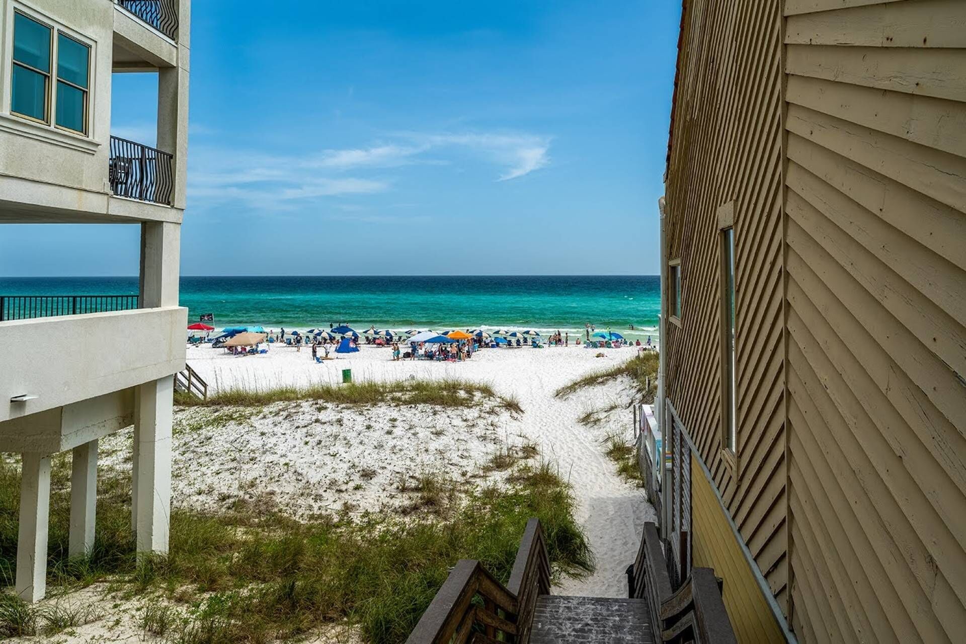 A beach view from a building with a balcony overlooking the beach.