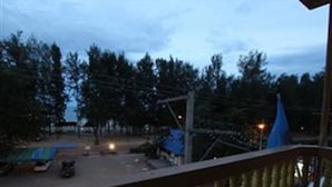 Ein Balkon mit Blick auf eine Straße und Bäume.