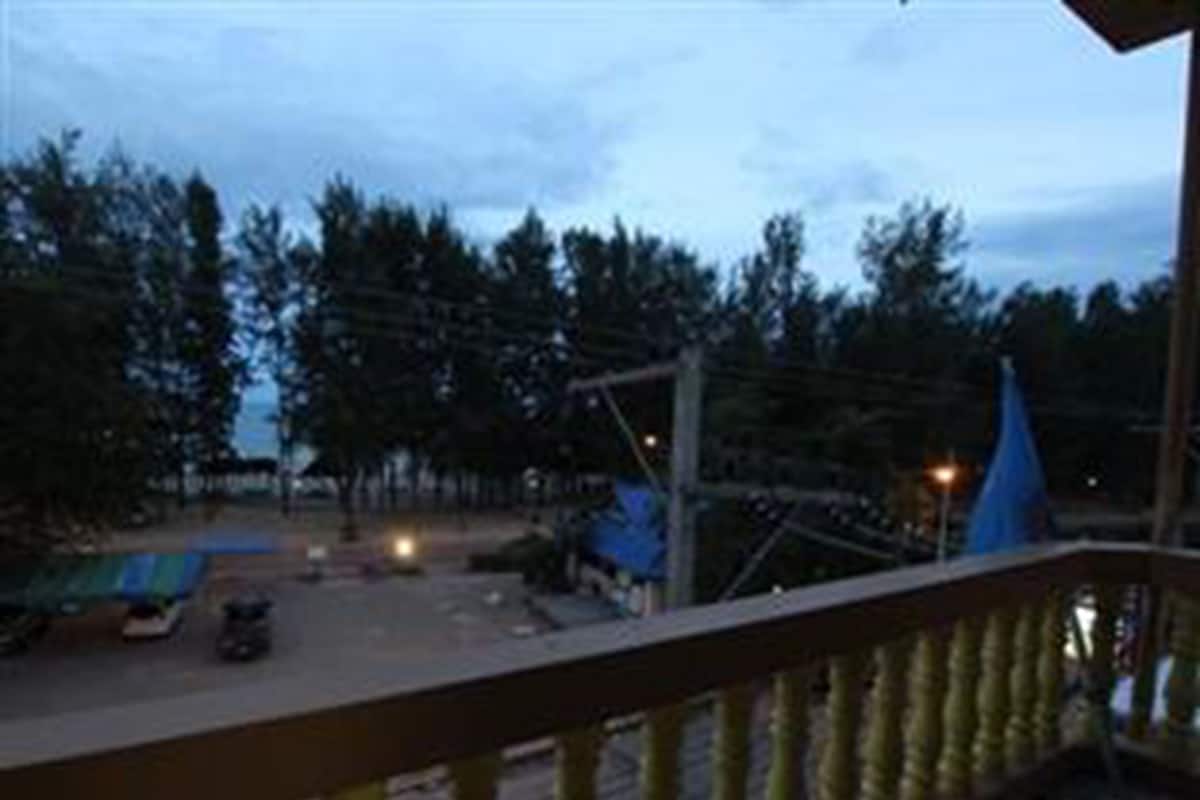 A balcony with a view of a road and trees.