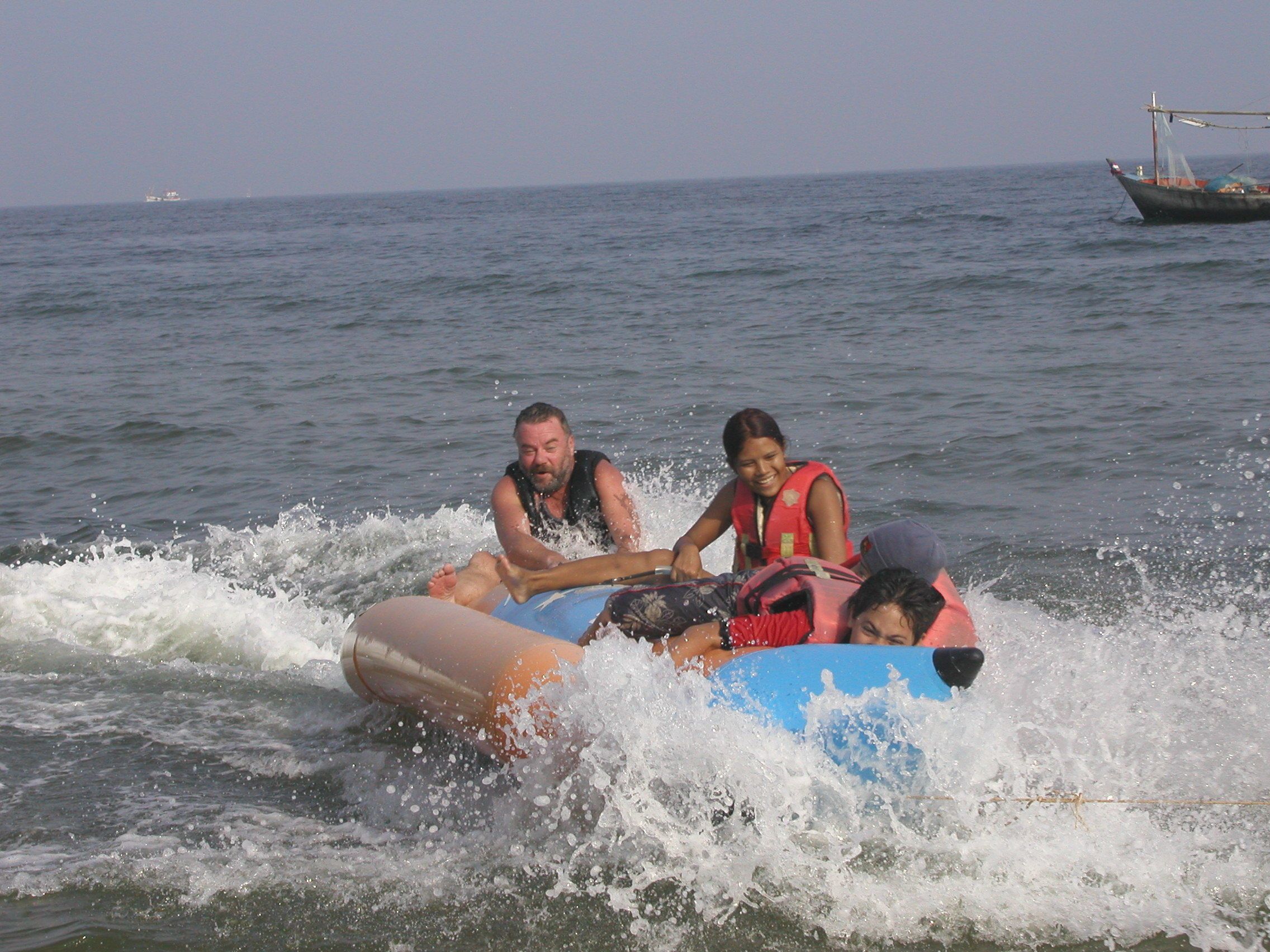 A group of people on a raft in the ocean.