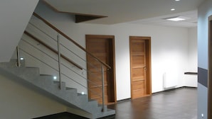 A modern interior with a staircase, two wooden doors, and a tiled floor. - Hotel Fojtů (Bruntal)