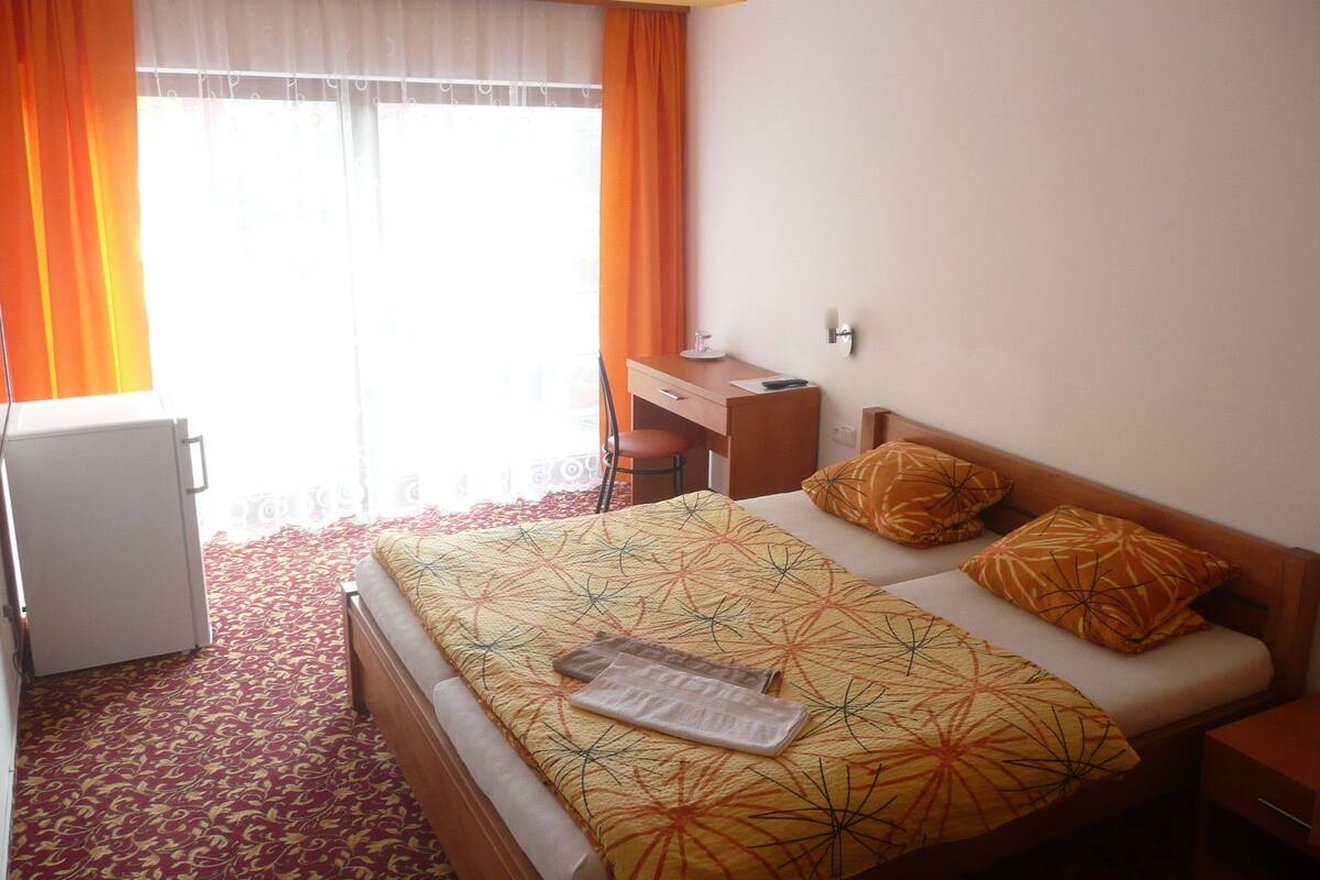A hotel room with a bed, a desk, and a chair.