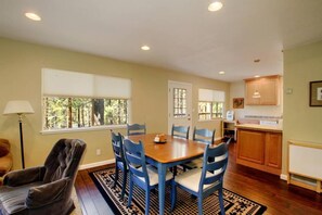 A dining area with a wooden table and blue chairs, a sofa, and a lamp. - Come play in the mountains, 4 bedrooms, quiet time, mid week discounts 1489O (South Lake Tahoe)
