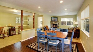 A dining area with a table and chairs, a fireplace, and a television.
