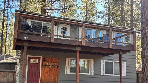A two-story cabin with a front door, a small porch, and a number '1489' on the side.