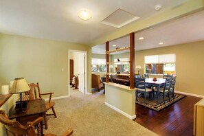 A spacious living area with a dining table and chairs, a sofa, and a fireplace.