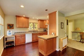 A kitchen with wooden cabinets, a built-in dishwasher, and a central island.