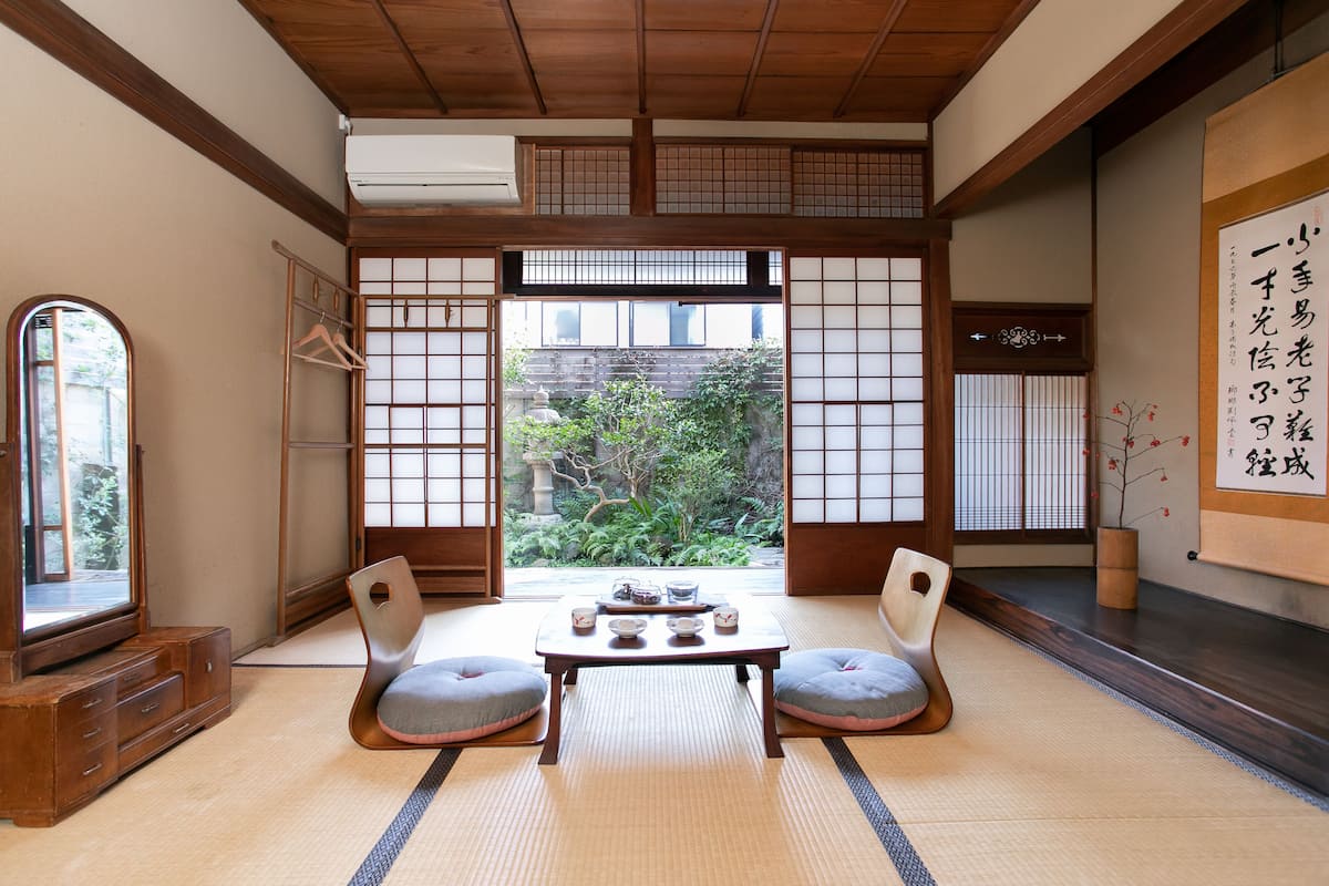 Ein traditioneller japanischer Raum mit Tatami-Bodenbelag, einem niedrigen Tisch mit Teeservice und Shoji-Schirmwänden.