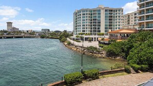 A waterfront hotel with a modern design, featuring a large building with multiple balconies and a view of the water.