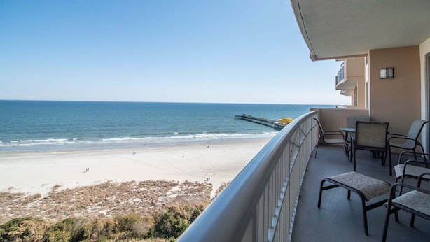 A balcony with outdoor furniture overlooking a beach and ocean. - $150 activities - E-gift card when you book - Luxury, Oceanfront Retreat - 2 King Beds | M804 (Myrtle Beach)