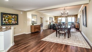 A spacious dining area with a chandelier, wooden dining table, and chairs. - $150 activities - E-gift card when you book - Luxury, Oceanfront Retreat - 2 King Beds | M804 (Myrtle Beach)