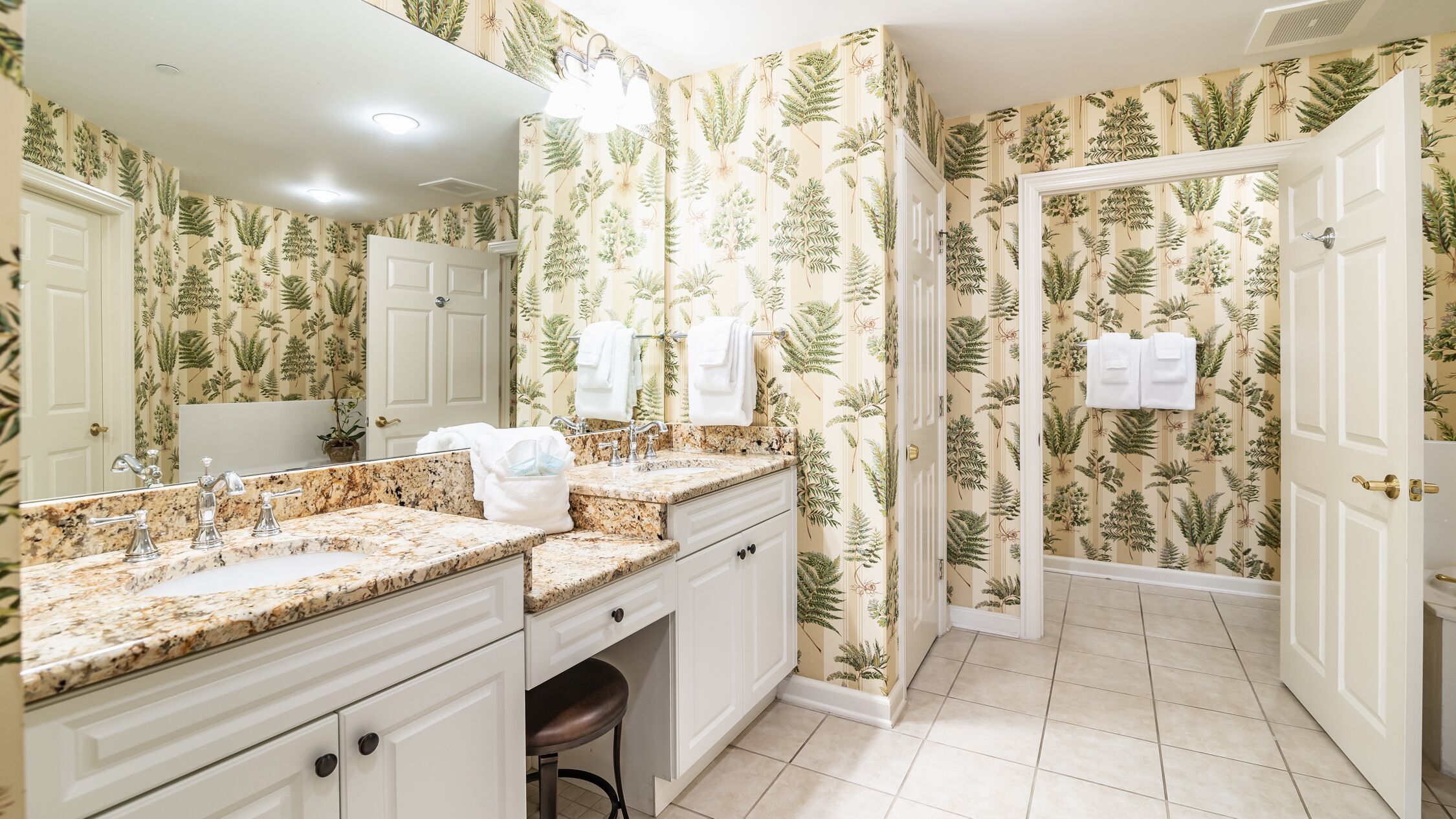 A bathroom with a large mirror, two sinks, and a bathtub.