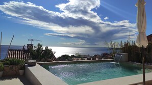 A swimming pool with a view of the sea, surrounded by rocks and plants. - Hacienda Babina, Island Cres, Lounge, Whirpool, Pool...Seaview (Miholascica)