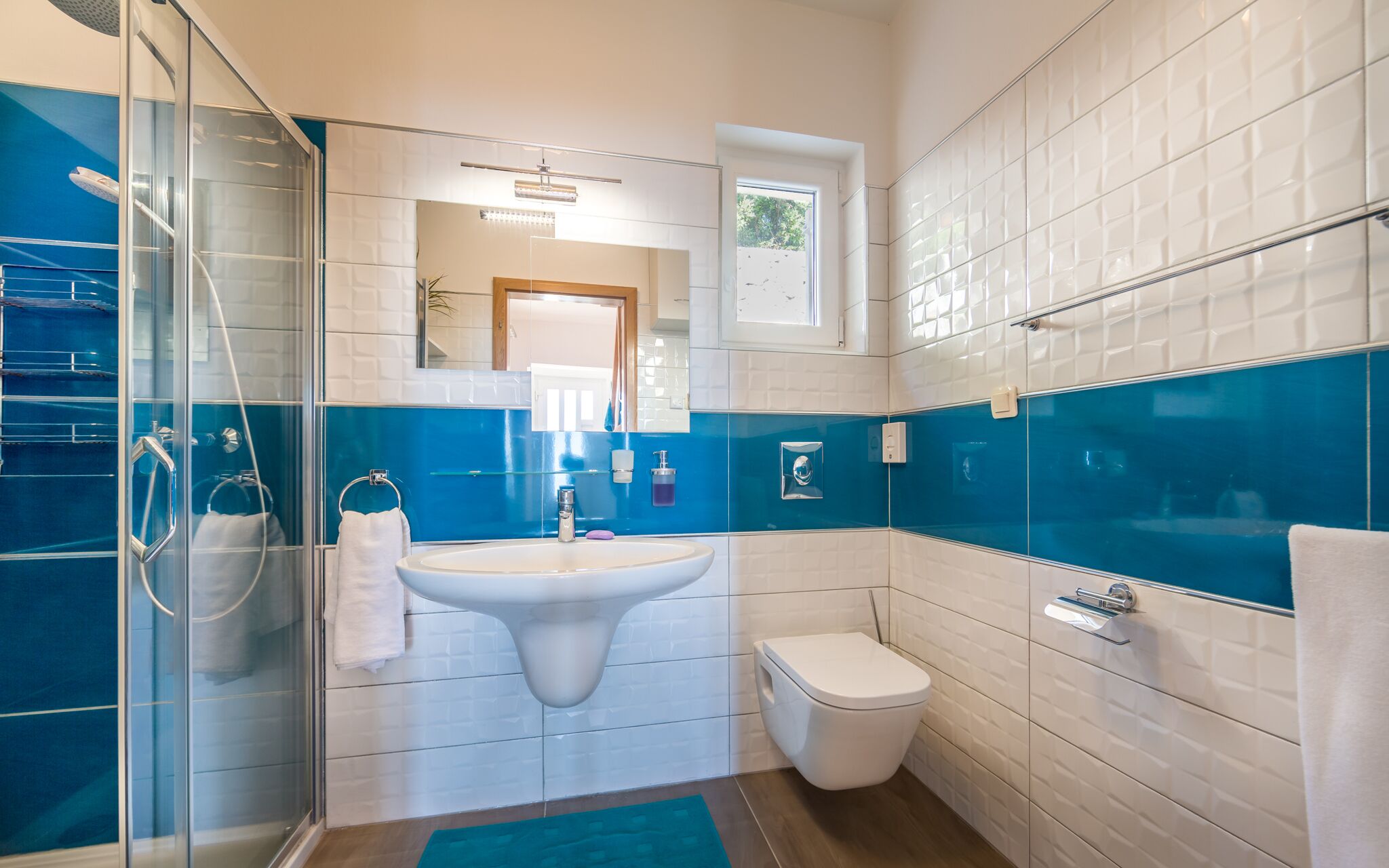 Ein modernes Badezimmer mit Duschkabine aus Glas, einem weißen Waschbecken und einer Toilette.