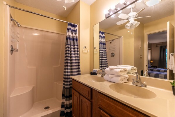 A bathroom with a shower, a sink, a mirror, and a ceiling fan. - Grand View - Mountain Views, Pool Table, Fire Pit (Banner Elk)