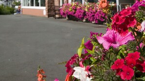 A hotel with a brick facade, large windows, and hanging flower baskets. - The Livermead House (Torquay)