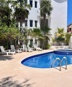 A pool area with white lounge chairs and a blue pool. - Las Tortugas A3 - beautiful 2 bedrooms condo on a beach side access in down town (Benito Juarez)