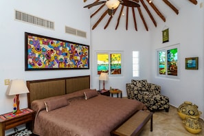 A bedroom with a large bed, a chair, a nightstand, a lamp, and a painting on the wall. - Las Tortugas A3 - beautiful 2 bedrooms condo on a beach side access in down town (Benito Juarez)