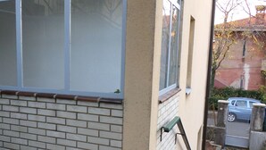 A view of a building with a brick facade and a window.